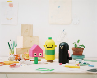 Colorful figures on a cluttered table by JR–Work–Shop for Acne Jr Toy Brand