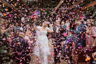 Wedding couple exits under shower of colorful confetti, taken by Todd and Alyda McGaw