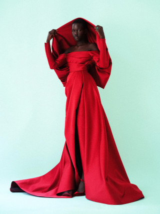Model in an elegant red gown posing with fabric draped over head, by Vivienne Balla
